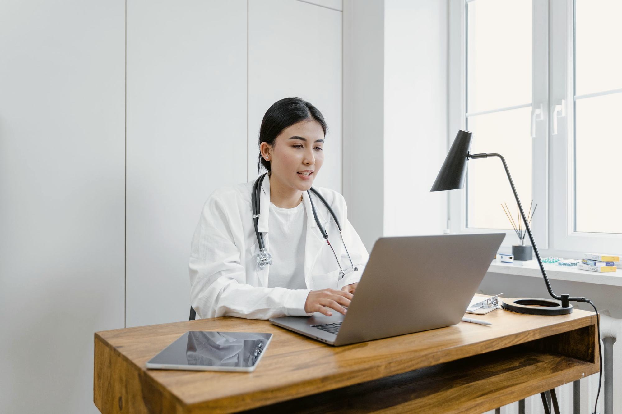 A doctor at work in her practice, at her computer